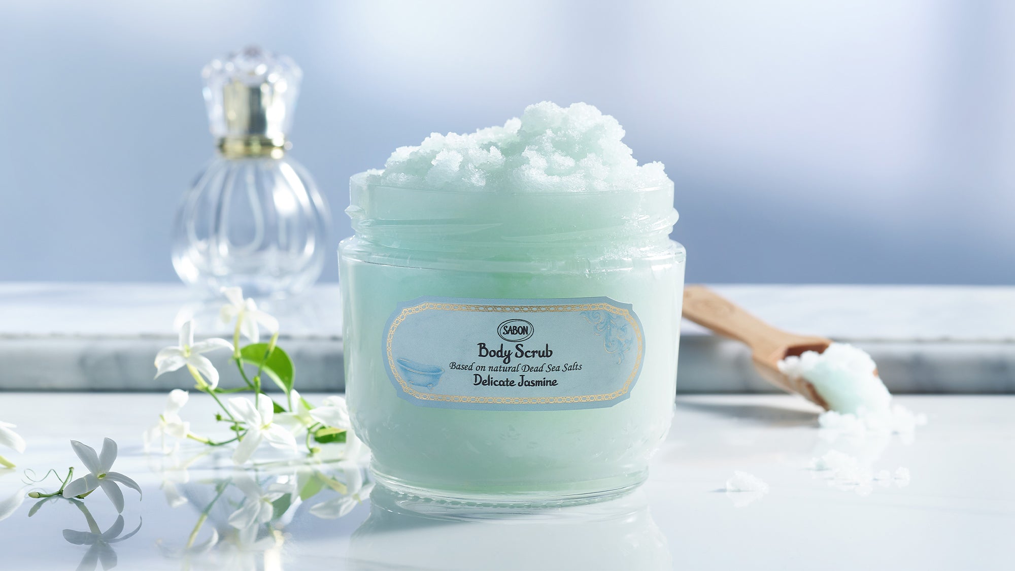 Sabon body scrub jar with delicate turquoise scrub and jasmine flowers